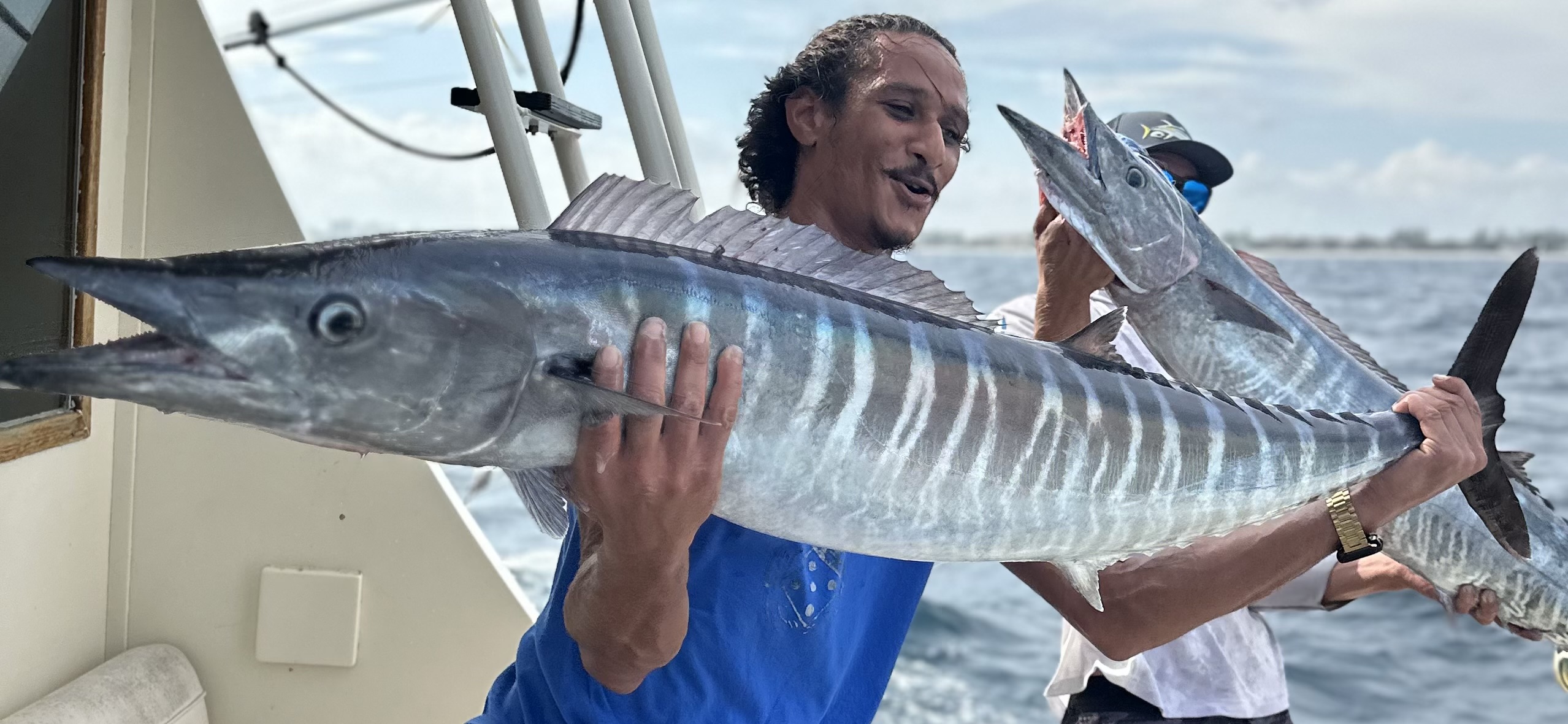 Angler holding wahoo caught on Boynton Beach deep sea fishing charter